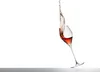 A wine glass with rosé wine splashing out of it, isolated on a white background. Podgląd zdjęcia produktu