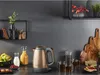A kitchen counter with a kettle, drinks, and fruit. Produktbild-Vorschau