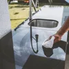 A person is cleaning an outdoor kitchen counter with a sink and faucet. Náhled obrázku produktu
