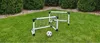 Two small soccer goals and a soccer ball are set up on a green lawn, with bushes in the background. Voir les images du produit