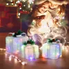 Two people, a child and an adult, are sitting on the floor surrounded by Christmas lights and decorated gift boxes. Anteprima dell’immagine prodotto