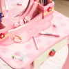A close-up view of a pink children's vanity table with various accessories. Produktbild-Vorschau