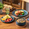 A breakfast setting with plates of food, fruit, and a glass of water on a wooden table. Náhled obrázku produktu