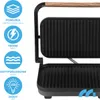 A close-up view of a black electric grill with a wooden handle, shown open. Icons and text describing product features are displayed on the left side. Produktbild-Vorschau