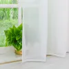 A white sheer curtain is shown in front of a window with greenery visible outside. Produktbild-Vorschau