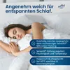 A woman sleeping peacefully on a bed, covered with white bedding. Produktbild-Vorschau