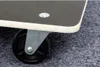 Close-up of a caster wheel and the edge of a dark platform on a grey carpet. Anteprima dell’immagine prodotto