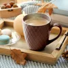 A cozy autumn scene with a mug of coffee, macarons, a candle, and fall leaves on a wooden tray. Produktbild-Vorschau