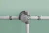 A close-up shot of a gray umbrella mechanism attached to white poles against a light green background. Produktbild-Vorschau