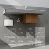 A white electronic water heater is mounted on a gray wall below a sink, with a wooden cabinet underneath. A table with product specifications is shown in the foreground. Produktbild-Vorschau