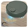 A dark green robot vacuum cleaner is shown cleaning a wooden floor, with dust and hair being sucked up. Produktbild-Vorschau