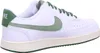 A side view of a white Nike Court Vision Low sneaker with green accents. Produktbild-Vorschau