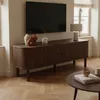 A living room scene featuring a TV stand with decorative items and a coffee table in the foreground. Anteprima dell’immagine prodotto