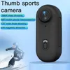 A black thumb sports camera is shown next to a skier on a mountain. Text overlays describe the camera's features. Náhled obrázku produktu