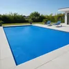 A rectangular swimming pool covered with a blue solar cover, surrounded by a paved area and greenery. Produktbild-Vorschau