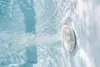 Underwater view of a jet in a pool or spa, with water flowing out. Náhled obrázku produktu