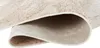 A close-up view of a rolled-up rug, showing the texture and underside. Produktbild-Vorschau