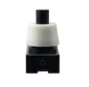 A close-up studio shot of a black and white push-button switch against a white background. Náhled obrázku produktu