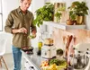 A man is preparing food in a modern kitchen, with a blender, stand mixer, and fresh produce on the counter. Náhled obrázku produktu