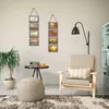 A cozy living room scene with a chair, ottoman, plant, and wall decor. Produktbild-Vorschau