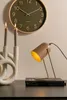 A desk scene with a clock, candles, and a lamp. Produktbild-Vorschau
