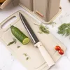 A knife, cucumber, and tomatoes are arranged on a cutting board, with a knife block in the background. Produktbild-Vorschau