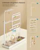 A white jewelry stand with various necklaces, earrings, and rings displayed on it. The stand is shown on a light beige surface, with additional product images and text on the right side. Produktbild-Vorschau