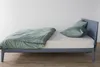 A side view of a bed with a duvet and pillows. Produktbild-Vorschau