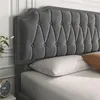A close-up view of a dark gray upholstered headboard and bed. Produktbild-Vorschau