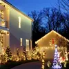 A house and garage decorated with Christmas lights at dusk. Produktbild-Vorschau
