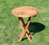 A wooden round folding table is placed on a grassy lawn. Produktbild-Vorschau