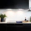 A modern kitchen scene with a stovetop and cookware. Voir les images du produit