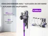 A cordless vacuum cleaner is shown mounted on a wall charger, with a spare battery and another vacuum cleaner unit on a shelf. Produktbild-Vorschau