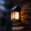 A close-up of a solar-powered outdoor wall light attached to a wooden surface. Produktbild-Vorschau