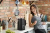 A woman is dancing in a kitchen next to a black electric kettle. Podgląd zdjęcia produktu