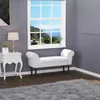 A white upholstered bench sits in a room with gray walls and a large window overlooking a scenic view. Náhled obrázku produktu