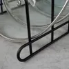 A close-up of a black metal pot lid rack holding a glass pot lid. Produktbild-Vorschau