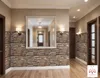 A hallway with stone-like wall panels and a large mirror. Produktbild-Vorschau