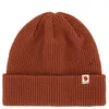 A close-up studio shot of a brown knitted beanie.