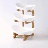 A three-tiered fruit and snack stand made of white bowls and a bamboo frame, presented against a white background. Náhled obrázku produktu