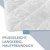A close-up of a white quilted blanket with a blue tag. Text is overlaid on the bottom left. Náhled obrázku produktu
