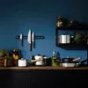 A kitchen counter with various cooking utensils and storage jars. Voir les images du produit