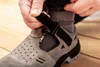 A person is fastening a safety sandal with velcro straps. Produktbild-Vorschau