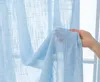 A hand holding a light blue sheer curtain with a linen-like texture. Produktbild-Vorschau