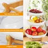 A multi-panel image showcasing a 3-tier fruit bowl stand with ceramic bowls and a wooden frame. The panels highlight design features like non-slip elements and irregular edges, while the main image displays the assembled product filled with various fruits. Produktbild-Vorschau