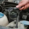 A person's hand is using a ratchet wrench to tighten a bolt in a car engine. Náhľad obrázku produktu