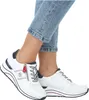 A person wearing white sneakers and blue jeans. Produktbild-Vorschau