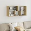 A wooden wall shelf with various decorative items is mounted on a white wall above a sofa with cushions. Náhled obrázku produktu