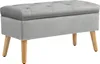 A gray upholstered storage bench with wooden legs against a white background. Náhled obrázku produktu