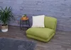 A green floor chair with a white pillow sits on a wooden floor in front of a gray wooden wall. Produktbild-Vorschau